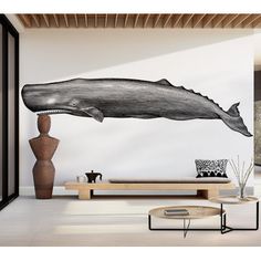 a living room filled with furniture and a large whale wall decal on the wall