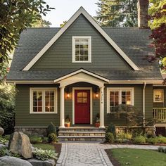 a house with a red door and brick walkway leading up to the front porch area