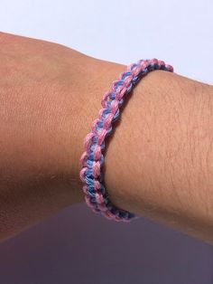 a person wearing a pink and blue bracelet