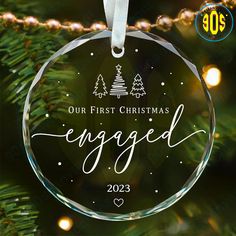 an ornament hanging from a christmas tree with the words engaged in white on it