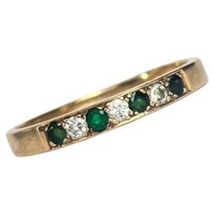 The emeralds in this ring are beautiful and deep green and measure 7pts each. In between the gorgeous green stones are diamonds which measure 7pts each also. The ring is modelled in 9carat gold. Ring Size: W 1/2 or 11 1/4 Band Width: 3.5mm Weight: 2.7g Green Diamond Half Eternity Ring, Green Half Eternity Ring For Anniversary, Green Half-eternity Ring For Anniversary, Classic Green Multi-stone Diamond Ring, Green Diamond Ring With Half Eternity Band, Green Diamond Half Eternity Ring For Anniversary, Green Diamond Ring For Anniversary With Half Eternity Band, Formal Green Half Eternity Jewelry, Green Diamond Half Eternity Round Cut Ring