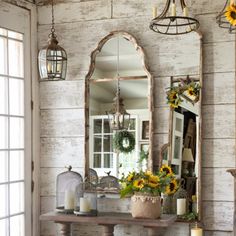 an entryway with sunflowers on the table and candles in front of it