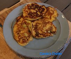 three pancakes on a plate sitting on top of a wooden table