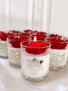 there are many small candles with red roses in them