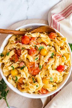 a white bowl filled with pasta and tomatoes