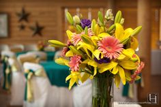 a vase filled with yellow and pink flowers