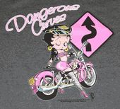 a woman riding on the back of a pink motorcycle next to a sign that says danger drive