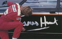 a man leaning on the side of a car with his head in the hood and writing on it