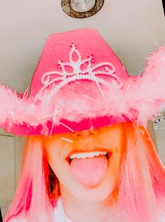 a woman with pink hair wearing a pink hat