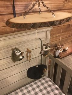 three stuffed animals hanging from hooks on the wall next to a wooden paneled wall