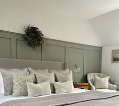 a large bed sitting in a bedroom next to two chairs and a table with flowers on it