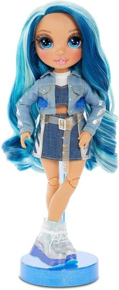 a doll with blue hair is standing on a white surface and wearing a denim outfit