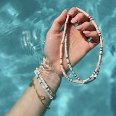 Bring alllllll the beach vibes anywhere you go with our Sealife Necklace. This beaded beauty comes in two sweet shades—a sand-inspired pink and sea-inspired turquoise—plus pops of silver or gold for a mini dose of shine. - Turquoise: brass base with rhodium plating & synthetic howlite beads- Sand: brass base with gold plating & synthetic howlite beads- Chain: 14" with 2" extension. Jump ring at 1" of extension.- Because jewelry products are handcrafted by artisans, dimensions may vary from piece Strand Jewelry For Beach Party, Colorful Beads Strand Jewelry For Vacation, Colorful Beaded Strand Jewelry For Vacation, Everyday Heishi Beads Bracelet For Summer, Heishi Beaded Bracelets For Everyday Summer Wear, Trendy Turquoise Heishi Beads Jewelry, Dainty Strand Beach Jewelry, Dainty Strand Jewelry For Beach, Summer Turquoise Necklace With Colorful Beads