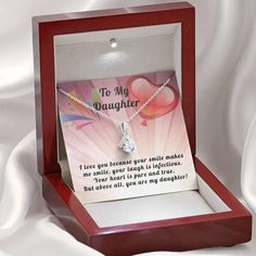 14k White Gold Over Stainless Steel 7mm round cut Cubic Zirconia ﻿Stylish gift box and message card Show your daughter how much you love her with this beautiful Alluring ribbon pendant necklace. This beautiful pendant is truly a one-of-a-kind gift for any daughter. The ribbon design is embellished with dainty cubic zirconia, which is followed by a beautiful 7mm round cut Cubic Zirconia. Crafted with 14k White Gold over Stainless Steel, this necklace dresses up any occasion. The adjustable oblate Father's Day Necklace With Gift Box, Valentine's Day Birthday Gift Wrapped Jewelry, Personalized Cubic Zirconia Jewelry For Mother's Day, Father's Day Personalized Jewelry Gift, Cubic Zirconia Jewelry For Mother's Day, Mother's Day Birthday Gift Wrapped Necklace, Gift-wrapped Necklace For Birthday On Mother's Day, Father's Day Jewelry Gift With Box, Round Necklace With Gift Box For Anniversary