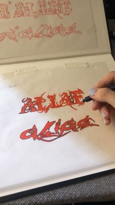 someone is writing in red ink on a piece of paper