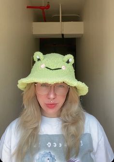 a woman wearing a green frog hat and glasses