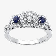 a diamond and sapphire ring with two blue stones on the shoulders, set in white gold