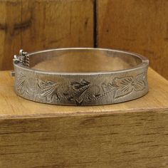 "Hinged diamond cut sterling silver bracelet from Mexico. S.G.E. Plata 925 Mex. 1/2\" wide.  1/8\" thick.  The inside measures 6 3/4\". The clasp locks securely.  There is a safety chain. Good condition with a pretty leaf pattern. Great looking bracelet. *The color on your screen may not reflect the actual stone color due to monitor variations.* BB-2" Sterling Silver Bangle With Engraving Option, Sterling Silver Bangle Bracelets With Engraving Option, Heirloom Silver Engraved Bracelets, Victorian Silver Jewelry With Engraving Option, Vintage Sterling Silver Hinged Bracelets, Silver Bangle Bracelet With Engraving Option, Heirloom Engraved Silver Cuff Bracelet, Victorian Silver Engraved Bangle, Victorian Style Silver Engraved Bangle