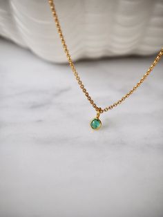 This tiny emerald necklace is the perfect daily necklace for emerald  lovers and May babies! The necklace is 14k gold filled with a beautiful natural Zambian Emerald pendant in a vivid green color in 18k solid gold setting. So beautiful! Layer it with your favorite necklaces, or wear it alone - it's perfect either way! The pendant is very small, approximately 4x7mm with a 3.5mm emerald. Each stone is unique and there will be slight variations in size. Emerald💚 Through time, the emerald has been Minimalist Gold Emerald Necklace With Delicate Chain, Dainty Gold Emerald Necklace With Delicate Chain, Gold Emerald Birthstone Necklace In Minimalist Style, Gold Minimalist Emerald Birthstone Necklace, Minimalist Gold Emerald Birthstone Necklace, Dainty Emerald Necklace With Delicate Chain For Everyday, Gold Dainty Emerald Necklace, Dainty Gold Emerald Round Necklace, Minimalist Gold Emerald Gemstone Necklace