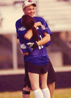 two soccer players hugging each other on the field