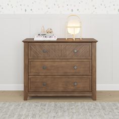 a wooden dresser sitting on top of a carpeted floor next to a white wall