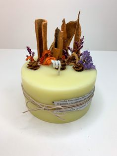 a yellow cake with purple and orange flowers on it's top, sitting on a white surface