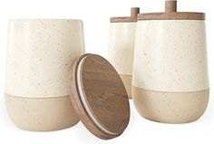 three white ceramic containers with wooden lids