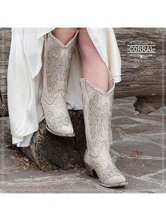 Introducing the Corral Women's Wing & Cross Studded Wedding Boots - the ultimate statement piece for brides who dare to be different. These exquisite white boots are designed to elevate your wedding style, taking you beyond the traditional and into a realm of bold, modern chic. Crafted from premium white leather, these wedding boots showcase an intricate wing and cross design brought to life by a stunning white glitter overlay. The silver studs sprinkled throughout the design exude sophisticatio White Embellished Boots With Pointed Toe, White Embellished Boots With Round Toe, Glamorous White Embellished Boots, White Snip Toe Party Boots, White Low Heel Party Boots, White Low Heel Boots For Party, Glamorous Embellished Wedding Boots, Elegant Embellished Snip Toe Boots, White Round Toe Boots For Wedding