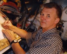 a man sitting in front of a drawing board