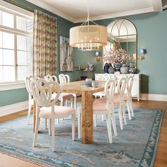 a dining room with blue walls and white chairs