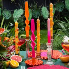 a table topped with lots of different types of candles and fruit on top of it