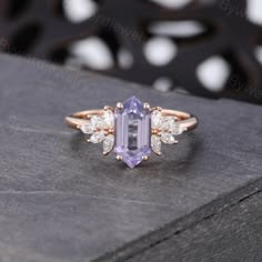 an amethorate and diamond ring sitting on top of a box