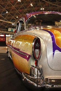 an old fashioned car is painted with metallic paint and has been displayed in a showroom