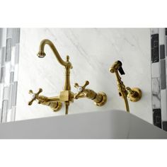 two golden faucets on the wall in a bathroom