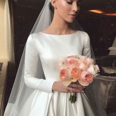 a woman in a wedding dress holding a bouquet of flowers