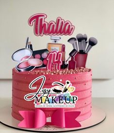 there is a pink cake with makeup on it and the words thalla up above it