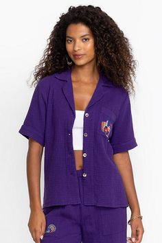 Crafted from 100% breathable cotton, the Desire Camp Shirt is embellished with intricate colorful embroidery at the front and back. Featuring a classic collared button-front, this relaxed-fit casual shirt is finished with a patch pocket at the chest. Pair with linen shorts and strappy sandals for a vibrant weekend look. Johnny Was Women's Camp Shirt in Violet Indigo Purple, Size Small, Linen/Cotton Summer Embroidered Top With Camp Collar, Embroidered Camp Collar Tops For Summer, Spring Vacation Embroidered Camp Shirt, Cotton Shirt With Floral Embroidery And Camp Collar, Summer Embroidered Button-up Camp Shirt, Embroidered Vacation Tops With Camp Collar, Cotton Camp Shirt With Floral Embroidery, Cotton Camp Shirt With Embroidered Camp Collar, Embroidered Button-up Camp Shirt For Summer