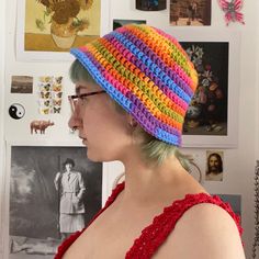 a woman with green hair wearing a multicolored crocheted beanie hat