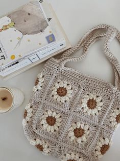 a crocheted purse sitting next to a cup of coffee and a knitting kit