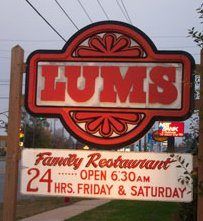 the lums restaurant sign is on the side of the road