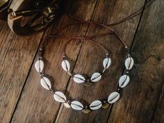 This set of a gold shell necklace and boho pearl bracelet is the perfect jewelry idea for beach lovers, ideal as a beach jewelry gift set and shell pendant to complete the perfect beach look. 𝐃𝐄𝐓𝐀𝐈𝐋𝐒 🌵 Jewelry set consisting of a shell necklace and matching bracelet, gold and brown details 🌵 Kauri shell, Linhasita macramé yarn, wooden brass beads, brass pendant 🌵 Adjustable length 🌵 Goes with boho, western/country looks 𝐕𝐄𝐑𝐒𝐀𝐍𝐃 📦 Processing time for handmade products 1-5 worki Gold Bohemian Shell For Festival, Handmade Gold Shell Strand, Handmade Gold Strand Shell, Adjustable Strand Jewelry Gift, Summer Gift Jewelry With Adjustable Length, Bohemian Shell Charm Necklace As Gift, Bohemian Shell-shaped Charm Necklaces, White Strand Jewelry Gift, White Strand Jewelry As Gift