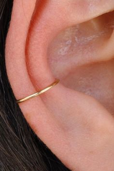 a close up view of a person's ear with a gold ring on it