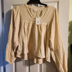 Never Been Worn Before Size: Medium Has A Flowy Fit Slightly Oversized Beige Long Sleeve Peasant Top For Daywear, Cream Long Sleeve Peasant Top For Daywear, Long Sleeve Beige Peasant Top For Daywear, Beige Relaxed Fit Top For Brunch, Beige Long Sleeve Cotton Peasant Top, Beige Long Sleeve Top For Daywear, Beige Long Sleeve Tops For Spring, Spring Oversized Neutral Blouse, Oversized Neutral Blouse For Spring