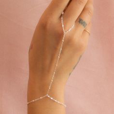 Our hand chains are a stylish piece of jewelry that connects a bracelet on your wrist to one of your fingers with delicate chains. This one is decorated with little beads, adding a unique and elegant touch. …………………………………. Details: Chain finishes 14k Gold Filled or Sterling Silver Waterproof and can be worn everyday Average bracelet size is 6.5" - 7" About Your Jewelry If you are not wearing your jewelry it is best to store it in a cool, dry place such as your gift box that is included in your or Silver Delicate Chain Body Chain As Gift, Silver Delicate Chain Body Chain For Gifts, Dainty Silver Body Chain For Gift, Delicate Silver Body Chain For Party, Silver Delicate Chain Body Jewelry As Gift, Lariat Body Jewelry With Adjustable Chain As Gift, Adjustable Silver Body Jewelry With Delicate Chain, Silver Chain Body Jewelry Gift, Silver Dainty Delicate Chain Body Chain