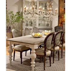 a dining room table and chairs with chandelier in the backround area