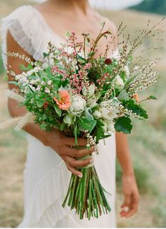 a woman holding a bouquet of flowers in her hands