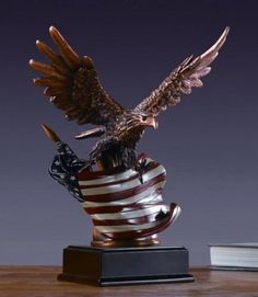 an eagle statue sitting on top of a coffee cup with the american flag in it