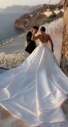 a bride and groom standing next to each other in front of an ocean view ceremony