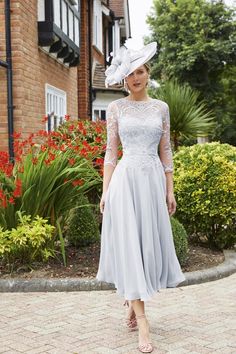 a woman wearing a white dress and hat