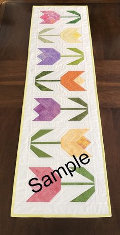 a table runner with the word sample written on it and an arrow design in black